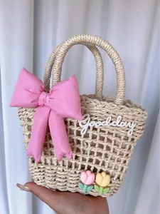 Detailed macro shot of beige woven tote bag with pink satin bow and tulip flower decor