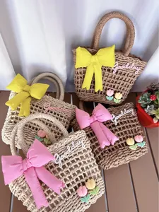 Close-up of woven straw bag detail with tulip flower appliques and Goodday embroidery