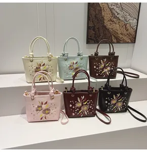 Sacs seaux brodés de motifs floraux en plusieurs couleurs sur des marches blanches