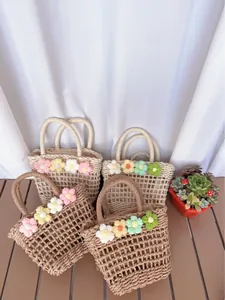 Detailed grid weave texture of handmade straw bags with colorful knitted floral accents