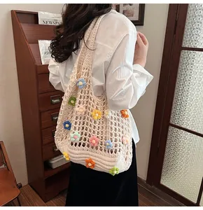 Dettaglio della borsa a rete all'uncinetto con fiori 3D colorati e trama beige