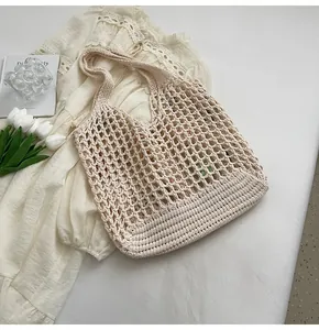 Dettaglio della borsa tote all'uncinetto beige con trama a rete e stile vacanza francese