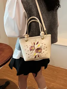 Sac seau blanc cassé élégant avec broderie florale et détail de poignée nouée