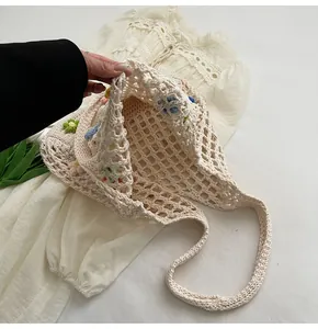 Dettaglio della borsa tote all'uncinetto con motivi floreali colorati e trama traforata