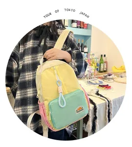 Detail of color-block backpack with blue cord zipper and brand label close-up