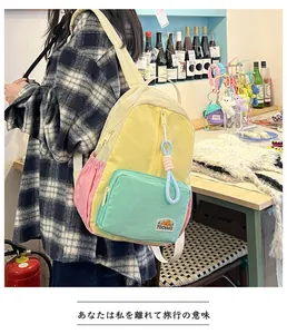 Close-up of colorful color-blocked backpack with brand label and cute pendant detail