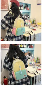 Detail of vibrant color-block nylon backpack featuring yellow, pink, and mint green panels