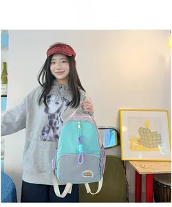 Detail of color-block backpack with light green, grey and lilac panels and brand patch