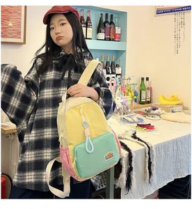 Detail of color-block canvas backpack with TOCHASO logo worn in a casual lifestyle setting