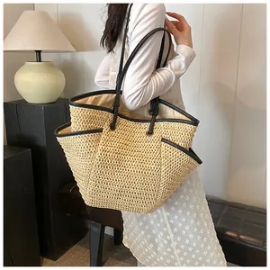 Détail d'un sac cabas en paille tissée avec garniture en cuir noir et poche latérale