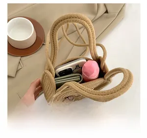 Vue macro de l'intérieur d'un sac en paille avec smartphone, portefeuille et produits