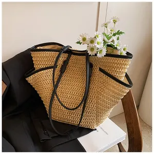 Détail du sac cabas en paille tissée avec anses en cuir noir et poches latérales