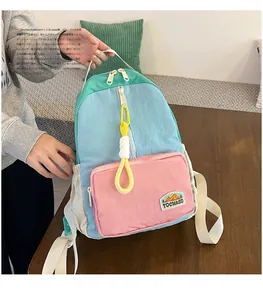 Detail of color-block nylon backpack with pink zipper pocket and branded patch logo