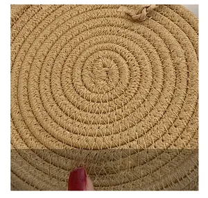Gros plan d'un sac à main circulaire en paille montrant les détails de couture et texture