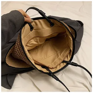 Détail de l'intérieur du sac en paille montrant la grande capacité et la poche zippée