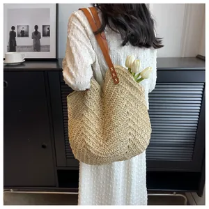Détail d'un sac cabas tissé à la main avec poignées en cuir marron et tulipes blanches