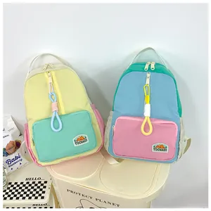 Detail of color-block mini backpacks with TOCHASO logo and decorative ring charms