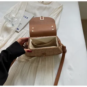 Detailed interior of woven straw bag with leather flap and metal clasp lock system