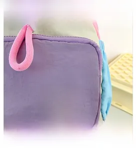 Close-up of the TOCHASO embroidered logo patch on a purple nylon front zipper pocket