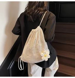 Détail d'un sac en maille crème avec fleur de marguerite 3D et texture tressée évidée