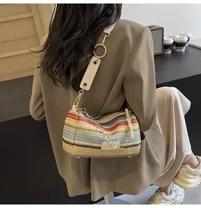 Detail of colorful rainbow woven shoulder bag with chic metal chain and wide strap