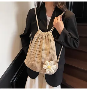 Détail du sac à dos au crochet beige avec cordon de serrage et décor de grande marguerite