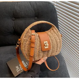 Nahaufnahme der Boho-Strohtasche mit brauner Lederklappe und goldenem Drehverschluss