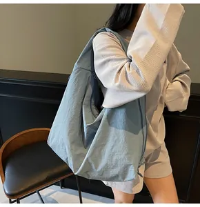 Detail of the large capacity light blue nylon tote bag showing texture and drape