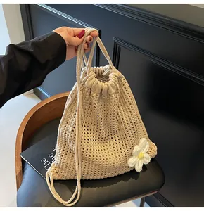 Vue détaillée du sac seau en crochet beige avec accessoire de fleur de marguerite