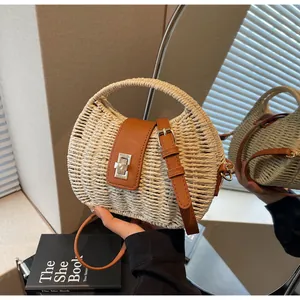 Detailaufnahme einer gewebten Strohtasche mit brauner Lederklappe und goldenem Drehverschluss