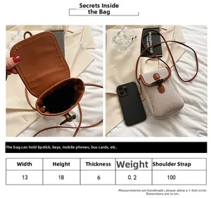 Size chart detail of a minimalist canvas crossbody bag with retro horn buckle closure
