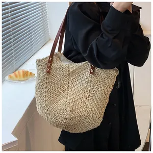 Détail du sac cabas en paille tissé avec motif en V beige et lanières en cuir brun