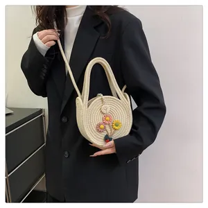 Vue détaillée du petit sac à main en paille tressée avec fleurs et coccinelle décorative