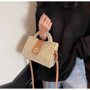Detailansicht der handgefertigten Strohtasche mit Lederriemen und goldenem Metallverschluss