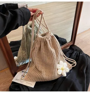 Détail du sac à dos crochet beige avec fleur 3D et fermeture à cordon de serrage