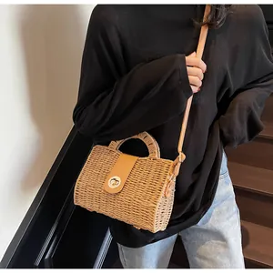 Detail der geflochtenen Strohtasche mit Lederklappe und goldenem Drehverschluss