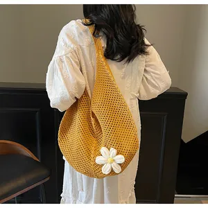 Close-up of bright yellow hollow knit tote bag featuring a 3D white floral decoration