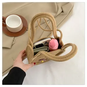 Vue détaillée du mini sac en paille tressée avec marguerite 3D montrant l'intérieur