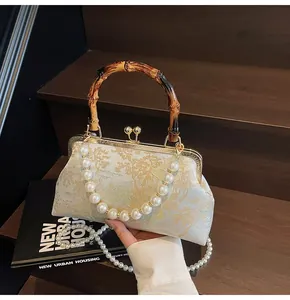 Detail von Bambusgriff und Goldbrokat-Landschaftsmuster auf einer Vintage-Handtasche