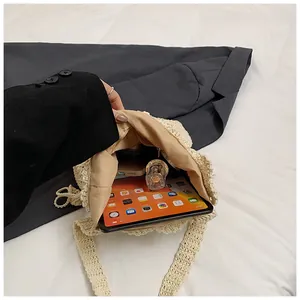 Interno spazioso della borsa intrecciata beige con tablet e prodotti cosmetici