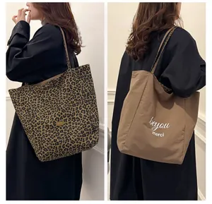 Detailed view of the reversible tote bag showing leopard print side and solid brown side
