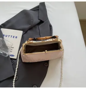 Detailansicht der rosa Jacquard-Tasche mit Bambusgriff und eleganter Perlenkette