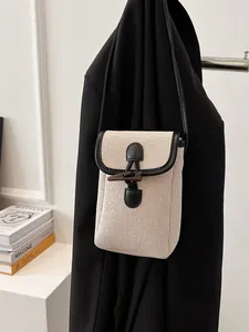 Minimalist beige canvas crossbody phone bag with horn buckle and black leather trim
