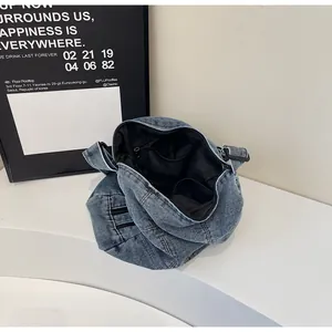 Detail view of denim shoulder bag interior with black lining and secure zipper pocket