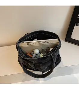 Vue de dessus du grand sac en jean contenant un ordinateur, un parapluie et une gourde