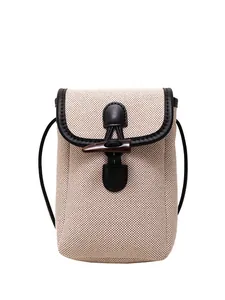 Beige canvas crossbody phone bag with black leather trim and vintage toggle closure