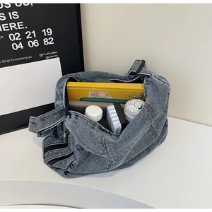 Macro view of washed denim messenger bag interior showing large storage capacity