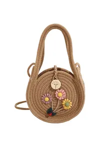 Mini sac à main rond en paille tressée avec fleurs 3D et coccinelle sur fond blanc
