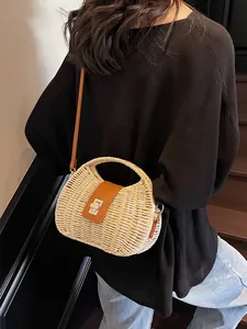 Beige Boho Strohhandtasche mit braunem Lederriemen und Silberverschluss am Modell gezeigt
