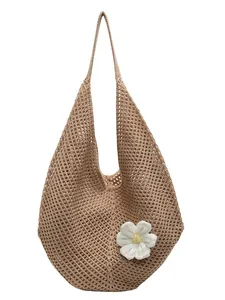 Chic hollow woven straw beach tote bag for women with decorative floral pendant charm